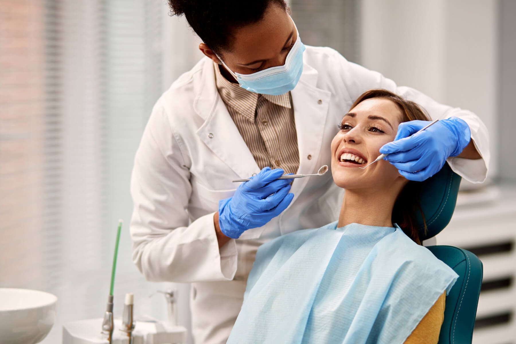 Dentist examining patient's teeth with dental tools - Monroe, WI